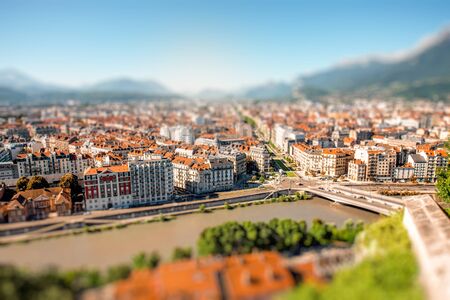 Morning cityscape view on the old town with mountains and river in Grenoble city on the south-east of France. Blurred image with tilt-shift technicの写真素材