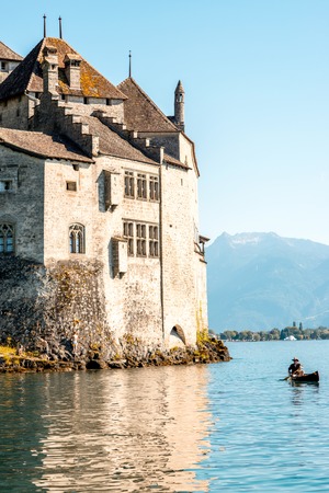 Veytaux, Switzerland - June 23, 2016: Landscape view on Geneva lake with Chillon castle and man in the boat in Switzelandのeditorial素材