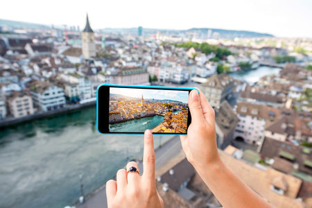 Photographing with smart phone aerial view on Zurich old town in Switzerland