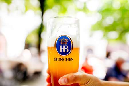 Munich, Germany - July 03, 2016: Famous bavarian Hofbrauhaus beer in the glass outdoors on the...