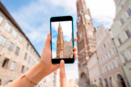 Photographing with phone saint Martin cathedral in bavarian town Landshut in Germanyの写真素材