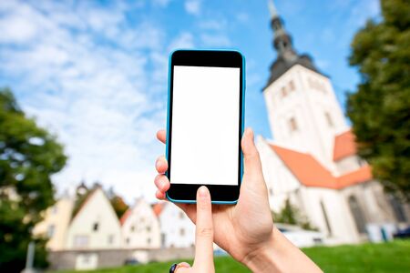 Phone with white screen on the old town background in Tallinn, Estoniaの写真素材