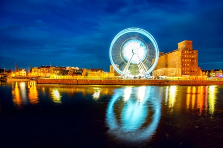 Night view on the riverside with illuminated Ferris wheel in the old city of Gdanskの写真素材