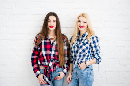 Female friends on the white wall background
