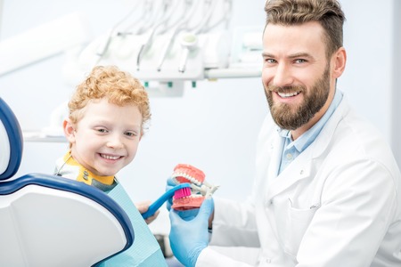 Dentist with boy at the dental officeの写真素材