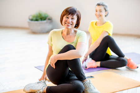 Young and older women doing yogaの写真素材
