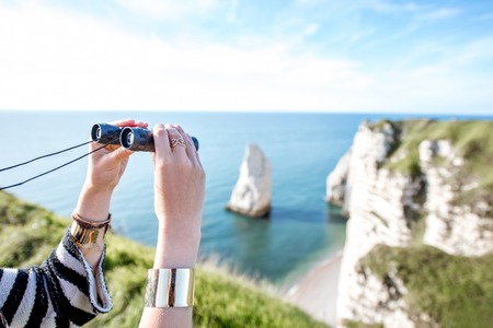Watching with binoculars near the oceanの写真素材