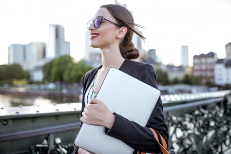Businesswoman with laptop outdoorsの写真素材