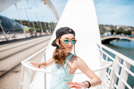 Woman in sportswear outdoors on the modern bridgeの写真素材