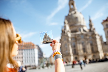 Woman holding a card with photo of Our Lady church in Dresden city, Germanyの写真素材