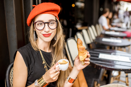 Woman having a french breakfast at the cafeの写真素材