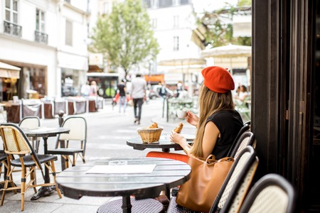 Woman having a french breakfast at the cafeの写真素材