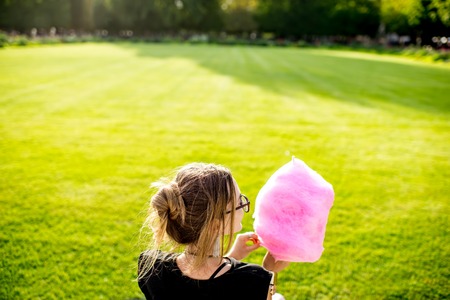 Woman with cotton candy at the parkの写真素材