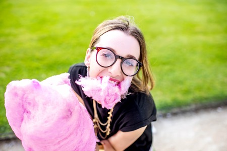 Woman with cotton candy at the parkの写真素材