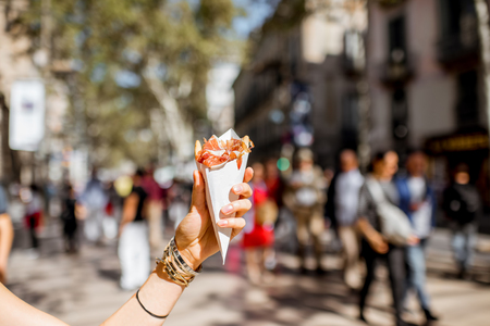 Holding jamon traditional spanish jerked meat outdoors on the street in Barcelonaの写真素材