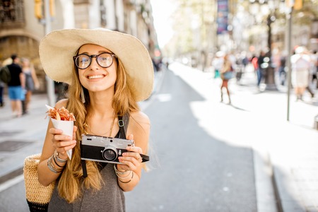 Young woman tourist holding jamon walking outdoors on the street in Barcelona cityの写真素材
