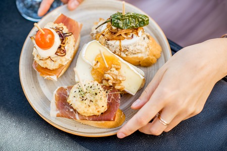 Beautiful and colorful set of pinchos, traditional spanish snack related to tapas, outdoors on the tableの写真素材