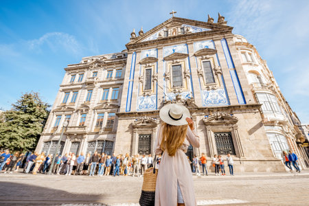 Young woman tourist standing near the Congregados church with famous portuguese blue tiles on the facade traveling in Porto city. Portugalの写真素材