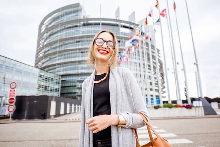 Lifestyle portrait of a young woman standing in front of the European parliament building in Strasbourg, Franceの写真素材