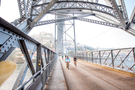 PORTO, PORTUGAL - September 24, 2017: View from below on the famous Luis iron bridge with people riding bicycles during the morning light in Porto, Portugalのeditorial素材