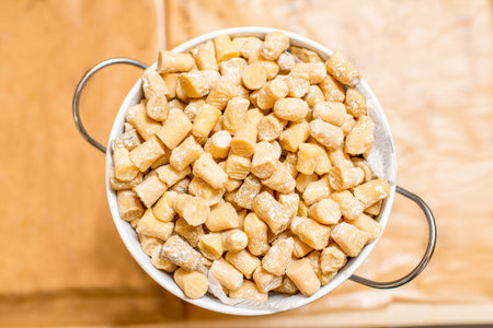 Top view on the bucket full of small seasoned cheeses