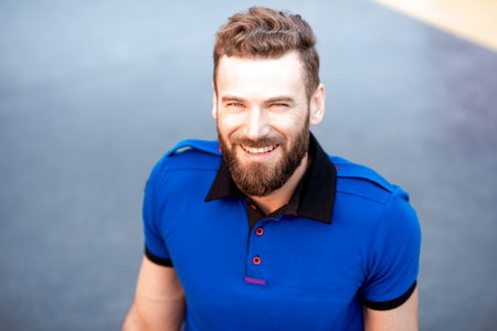 Close-up portrait of a handsome man in blue t-shirt outdoorsの写真素材