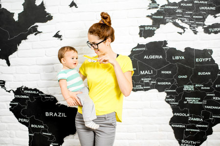 Man holding a colorful bubble above the head sitting at the office with world map on the background...