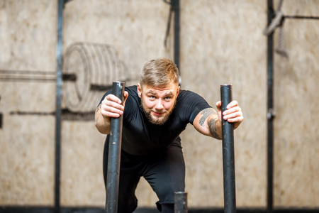 Strong man pushing sled with weights in the gymの写真素材