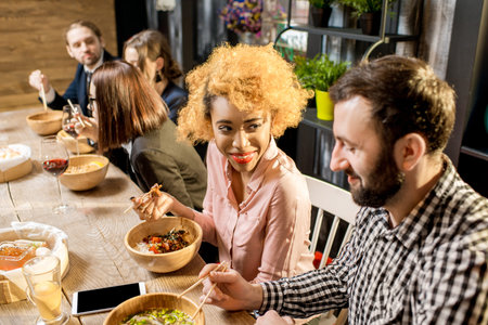 Beautiful multi ethnic couple sitting during the dinner with asian food in the restaurantの写真素材