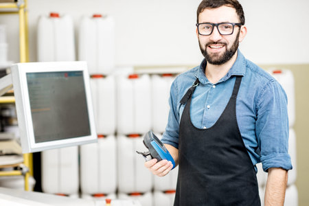 Portrait of a male worker standing near the operating desk of the printing manufacturing