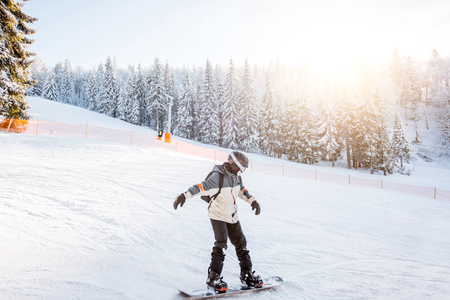 Landscape view on the snowy mountains with slopes and snowboarder riding during the sunny weatherの写真素材