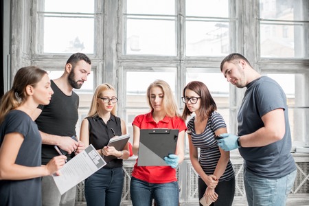 A group of people standing together with instructor during the first aid training indoorsの写真素材