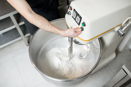 Mixing a dough for bread baking with professional kneader machine at the manufacturingの写真素材