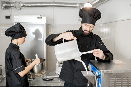 Chef pouring basis into the ice cream freezer machine in the small manufacturingの写真素材