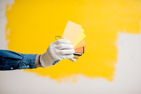 Holding color swatches on the yellow painted wall backgroundの写真素材