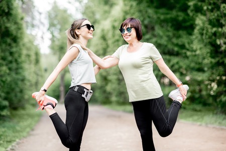 Young and elder sports woman stretching in the park during the morning exesrciseの写真素材