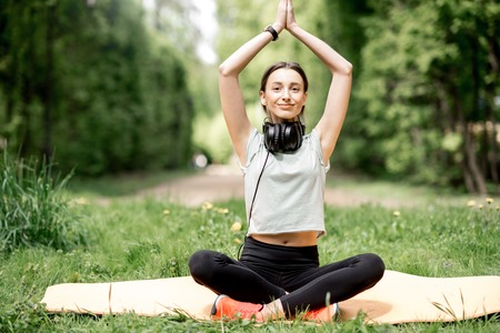 Young woman meditating during the yoga exrecise in the parkの写真素材