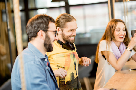 Young colleagues dressed casually sitting together during the coffee break in the cafeの写真素材
