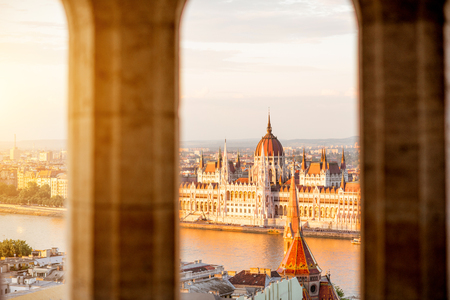 Cityscape view trhough the arch on the famous Parliament building during the sunset light in Budapest, Hungaryの写真素材