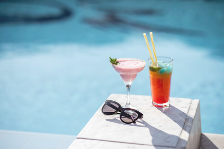 Close-up of summer cocktails on the beautiful blue water background during the sunlightの写真素材