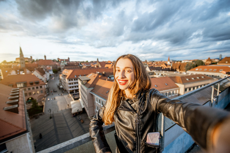 Young and happy woman tourist taking selfie photo on the cityscape background traveling in Nurnberg, Germanyの写真素材