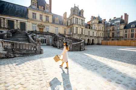 FONTAINBLEAU, FRANCE - August 28, 2017: Woman walking near the beautiful staircase visiting famous Fontainebleau palace in Franceのeditorial素材