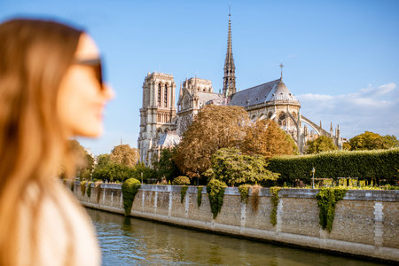 Cityscape view on the famous Notre-Dame cathedral on Seine river with woman face on the foreground in Paris, France. Focus on the backgroundの写真素材