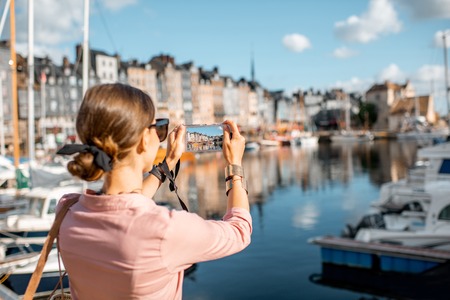 Young woman tourist enjoying beautiful view on the harbour traveling in Honfleur town in Normandy, Franceの写真素材