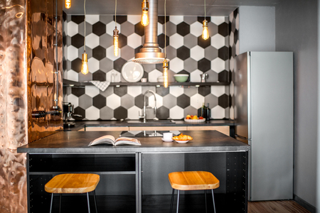 Loft kitchen interior with hexagonal black and white tiles and copper wallの写真素材