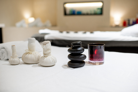 Herbal bags with stones for massage on the white towel indoorsの写真素材