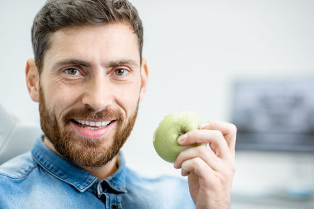 Portrait of a handsome bearded man with healthy smile in the dental office