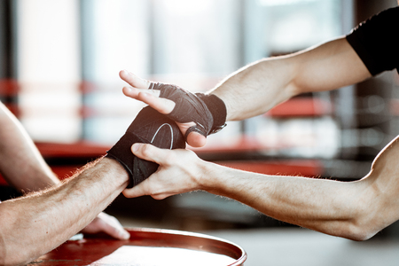 Close-up of a mens hands wrapped with boxing bandages in the gymの写真素材