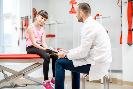 Physiotherapist during the medical consultation at the rehabilitation clinic with suspension medical equipmentの写真素材