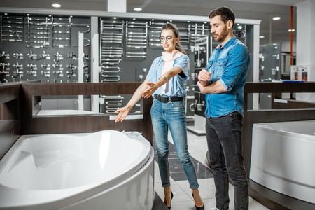 Man and woman choosing new bathtube standing together in the plumbing shopの写真素材